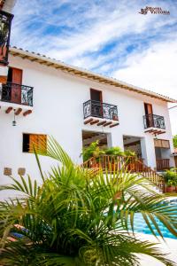 a white building with balconies and plants in front of it at Hotel Victoria Barichara in Barichara