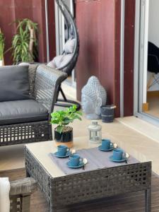 a coffee table with blue cups and saucers on it at Beach condo Porto mós (sea view) in Lagos
