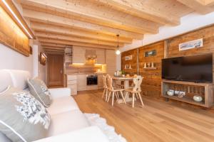 ein Wohnzimmer mit einem weißen Sofa und einem TV in der Unterkunft Chalet Laura in Alleghe