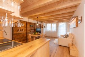 a kitchen and living room with wooden walls and ceilings at Chalet Laura in Alleghe