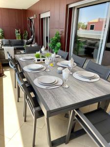 a dining room table with plates and glasses on it at Beach condo Porto mós (sea view) in Lagos