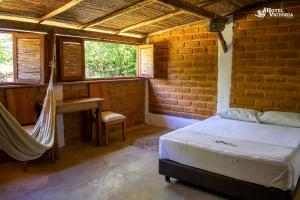 1 dormitorio con 1 cama, escritorio y ventanas en Hotel Victoria Barichara en Barichara