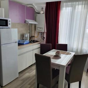 una piccola cucina con tavolo e frigorifero bianco di Summerland Apartament a Mamaia