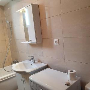 bagno con lavandino, servizi igienici e specchio di Summerland Apartament a Mamaia