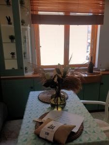 un tavolo con un vaso di fiori sopra di Amalthea Guest House a Città di Kos