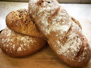 three loaves of bread sitting on a cutting board at The Angel Inn B&B in Long Crendon