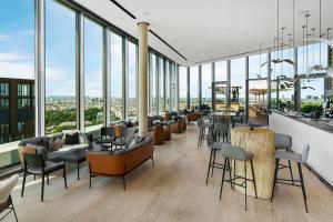 a lobby with couches and tables and windows at Andaz Vienna Am Belvedere - a concept by Hyatt in Vienna