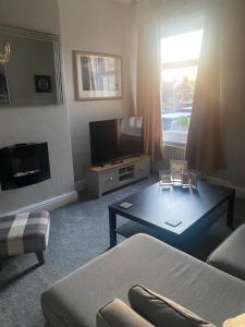 een woonkamer met een bank en een salontafel bij 1 bedroom spacious apartment in Lytham St Annes