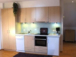 a kitchen with white appliances and wooden cabinets at Haus Leufke in Lenzkirch