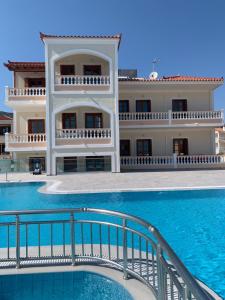 a large building with a swimming pool in front of it at Anemos Apartments in Marathokampos