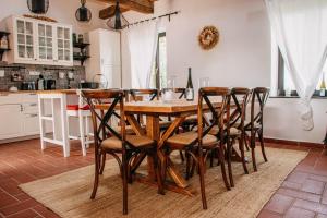 cocina con mesa de madera y sillas en Káli Panorama Resort, en Mindszentkálla