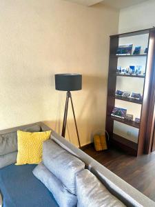 a living room with a gray couch with a yellow pillow at Luxury apartment in city center in Spišská Nová Ves