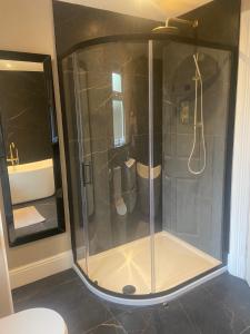 eine Dusche mit Glastür im Bad in der Unterkunft Bayview Apartments in Ballygalley