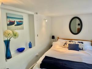 Airds Farm Guest House في قلعة دوغلاس: غرفة نوم مع سرير مع مرآة و مزهرية مع الزهور