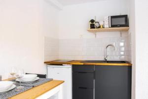 eine Küche mit einer Spüle und einer Theke mit Tellern in der Unterkunft Le OSLO, à 50m de la gare TV connecté+Fibre in Poitiers