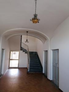 pusty pokój ze schodami i żyrandolem w obiekcie Casa Sofia w mieście Novi Ligure