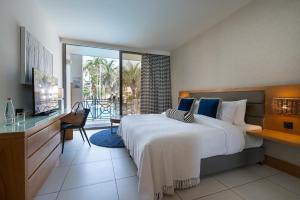 una camera da letto con un letto grande e un balcone di Agamim by Isrotel Collection a Eilat