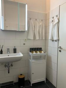 a white bathroom with a sink and a mirror at Zentral 72qm Style Küche Boxspringbett 1 Parkplatz in Osnabrück
