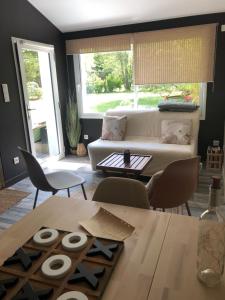 sala de estar con sofá blanco y mesa en IBI ENJOY, en Ligné