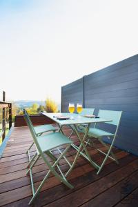 a table and chairs on a deck with two glasses of wine at Studio Juliette in Stavelot