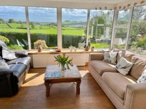 a living room with two couches and a coffee table at Airds Farm Guest House in Castle Douglas