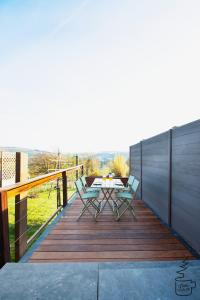 a wooden deck with a table and chairs on it at Studio Juliette in Stavelot