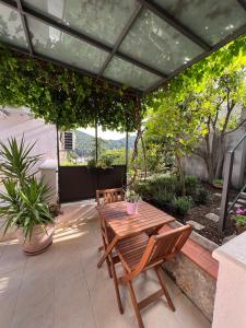 un patio con mesa de madera y sillas en Apartment Eden, en Dubrovnik