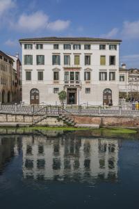 un grande edificio accanto a un corpo idrico di Le Camere di Palazzo Bortolan a Treviso
