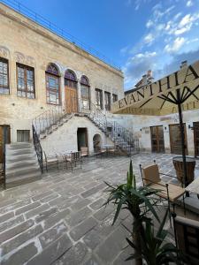 a building with stairs and tables and chairs in a courtyard at Evanthia Cave Suites in Ürgüp