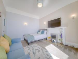 a living room with a blue couch and a fireplace at Apartment 1 Large Studio Sea Front- Sea Views- Free Parking in Paignton