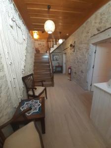 a room with a staircase with a chair and a table at Merlara Otel Alaçatı in Alaçatı