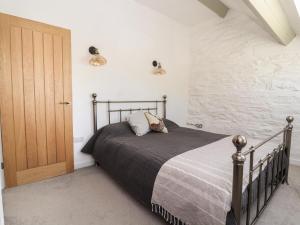 a bedroom with a bed and a wooden door at The Coach House in Llangollen