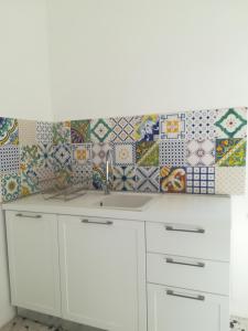 a kitchen with a sink and tiles on the wall at Tramonti E Valli in Calvi dellʼ Umbria