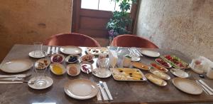 a table with plates and bowls of food on it at Evanthia Cave Suites in Ürgüp