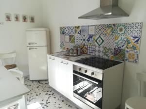 cocina con fogones blancos horno de arriba junto a una nevera en Tramonti E Valli, en Calvi dellʼ Umbria