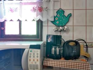 encimera de cocina con microondas en un estante en Bragança's Houses, en Cabo Frío