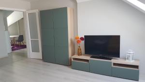 Promenad Apartman في موهاكس: غرفة معيشة مع تلفزيون بشاشة مسطحة على خزانة