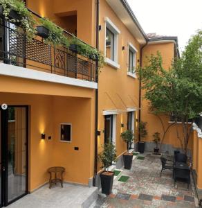 a courtyard of a building with chairs and trees at Vila Jasmine in Tirana