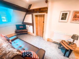 ein Wohnzimmer mit einem Sofa und einem Tisch in der Unterkunft The Loft at Riverside Suites Bridgnorth in Bridgnorth