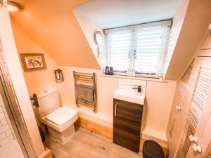 a bathroom with a toilet and a sink and a window at The Loft at Riverside Suites Bridgnorth in Bridgnorth