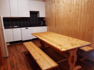 einen Holztisch in einer Küche mit weißen Schränken in der Unterkunft VARANGER KITE CAMP in Austertana