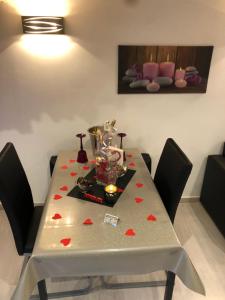 una mesa de comedor con corazones rojos. en Appartement Love room avec jacuzzi et hammam privatisé Lieu insolite en amoureux Spa détente assurée avec de doux massages en options sur demande en Orgon