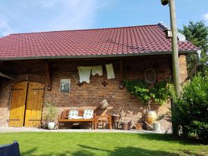 una casa de ladrillo con una mesa y sillas en un patio en Ferienhof Sommergarten, en Markische Heide