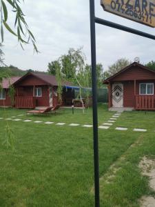 a sign in a yard with two buildings at Căsuțele Deltei in Mahmudia