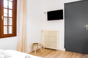 a bedroom with a bed and a table and a tv at Le Carnot, à 50m de la gare de Poitiers ! in Poitiers