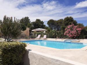 a swimming pool with two lawn chairs and flowers at Gîte provençal indépendant avec piscine chauffée : LE SUY BIEN in Flayosc
