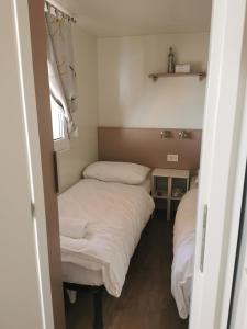duas camas num pequeno quarto com lençóis brancos em Adriatik Escape em Privlaka