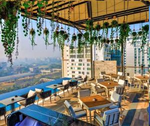 a restaurant with tables and chairs on top of a building at Best Western PLUS Maya - Luxury Collection Hotel in Dhaka