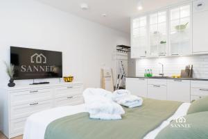a white kitchen with towels on a bed in a room at Apartament Baltic Amber z dostępem do basenów,strefy saun, jacuzzi przez cały rok- Pinea Apartments Pobierowo-SANNEL Apartments for rent in Pobierowo