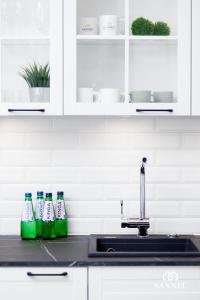 a kitchen counter with soda bottles on a sink at Apartament Baltic Amber z dostępem do basenów,strefy saun, jacuzzi przez cały rok- Pinea Apartments Pobierowo-SANNEL Apartments for rent in Pobierowo